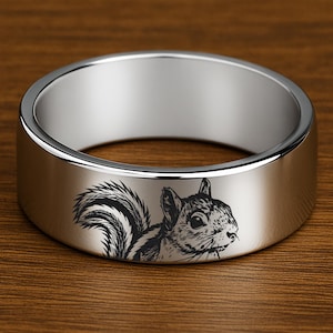 May include: A silver ring with a squirrel engraved on the band.