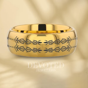 Może przedstawiać: Złota obrączka ślubna z czarnym grawerowanym wzorem dwóch mieczy splecionych z motywem winorośli. Obrączka ma szczotkowane wykończenie i fazowane krawędzie.