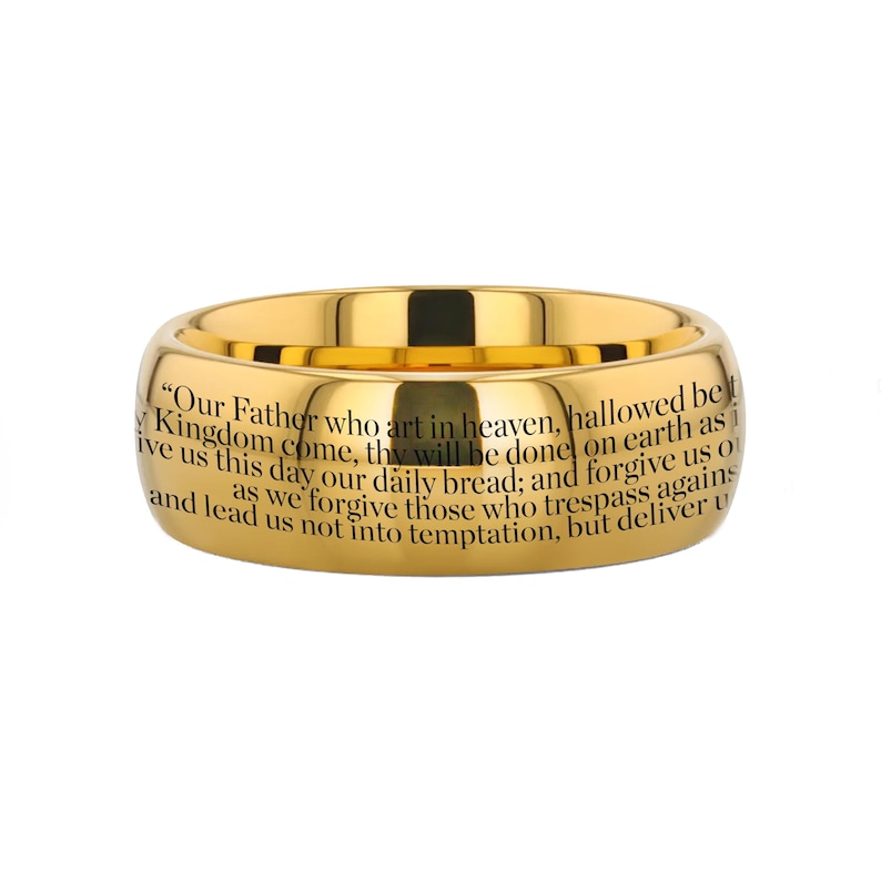 May include: A gold-colored ring with the Lord's Prayer engraved on the band. The text is in black and reads "Our Father who art in heaven, hallowed be thy Kingdom come, thy will be done on earth as it is in heaven. Give us this day our daily bread; and forgive us our trespasses, as we forgive those who trespass against us. And lead us not into temptation, but deliver us from evil. Amen."