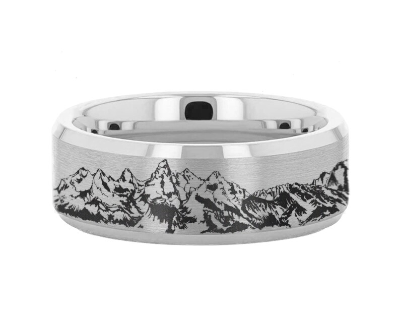 May include: A silver wedding band with a brushed finish and an engraved mountain range design.