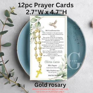 Puede incluir: Un juego de 12 tarjetas de oración, cada una de 6,8 cm de ancho y 12 cm de alto, con un rosario dorado y texto en español. Las tarjetas tienen un fondo blanco con ilustraciones florales y de palomas. El texto incluye el nombre "Olivia Lucia".