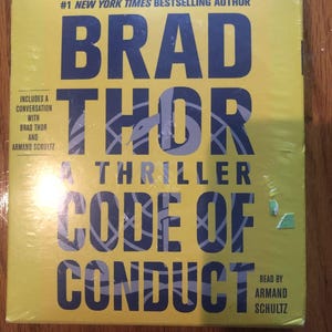 Könnte beinhalten: Ein gelber Buchumschlag mit dem Titel "Code of Conduct" von Brad Thor, einem #1 New York Times Bestseller-Autor. Das Cover zeigt eine Schlange und den Text "A Thriller".