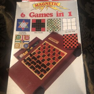 May include: A box for a magnetic travel game set with the words "6 Games in 1" and "Magnetic" on the front. The box shows images of the different games included: Chinese checkers, solitaire, checkers, snake and ladders, and tic-tac-toe.
