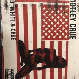 May include: A CD cover with a red, white, and blue American flag design. The cover features a woman in a red and black bikini sitting on the flag. The text "RED, WHITE & CRUE" is on the left side of the cover and "MÖTLEY CRÜE" is on the right side. The cover also includes a parental advisory label.