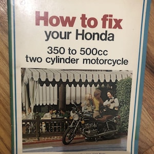 Puede incluir: Una portada de libro vintage con un borde azul, verde y blanco. La portada presenta una foto de una motocicleta y el texto "How to fix your Honda 350 to 500cc two cylinder motorcycle". El texto "Easy to Understand Fully Illustrated Save Time Save Money" está impreso en la parte inferior de la portada.