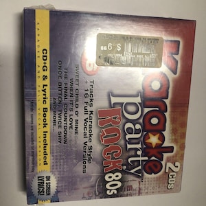 May include: A red and white karaoke party rock 80s CD+G and lyric book set with 2 CDs. The set includes 16 full vocal versions of popular rock songs from the 1980s, including "Sweet Child o' Mine" by Guns N' Roses, "When It's Love" by Van Halen, and "The Final Countdown" by Europe.