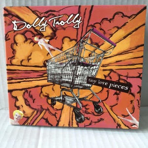 May include: A colorful album cover with a shopping cart flying through the air. The album cover is for the band "Dolly Trolley" and the album title is "tiny love pieces".