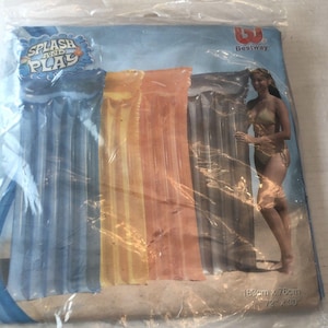 Puede incluir: Tres flotadores de piscina inflables en azul, amarillo y naranja. Los flotadores son rayados y tienen el logotipo 'Splash and Play'. El paquete también incluye el logotipo de la marca Bestway y las dimensiones: 72" x 30".