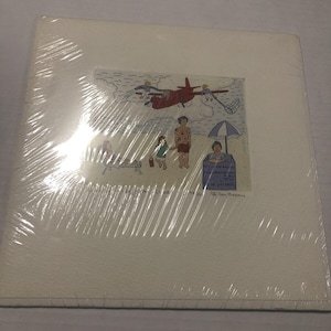 May include: A colorful illustration of a beach scene with people and a red airplane flying in the sky. The illustration is framed and has a white background.