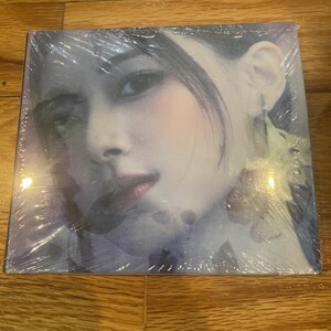 May include: A square, shrink-wrapped album cover featuring a close-up portrait of a person with light skin, dark hair, and a soft, dreamy aesthetic. The person is looking towards the viewer. The background is a soft, blurred mix of colors.