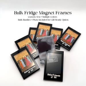 May include: A collection of black rectangular fridge magnet frames, some containing a photograph of a group of people and the text "SisterFriends of '88". One frame is empty, showing the "instax FUJIFILM" logo on its clear plastic surface.