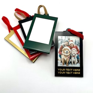 May include: Rectangular photo ornaments in various colors, including red, gold, black, and green. Each ornament has a velvet ribbon for hanging. One ornament displays a family photo with the text "YOUR TEXT HERE".