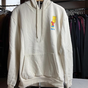 May include: A white ceramic mug with a black handle and the text "But First, Coffee" in a black, handwritten-style font. The mug is on a white surface.