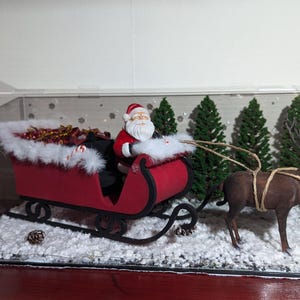 Papá Noel en trineo y renos en 3D. Decoración navideña festiva impresa en 3D y pintada a mano con luces de cadena de 3 posiciones