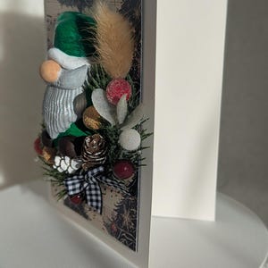 Tarjeta navideña 3D hecha a mano con gonk y vegetación artificial