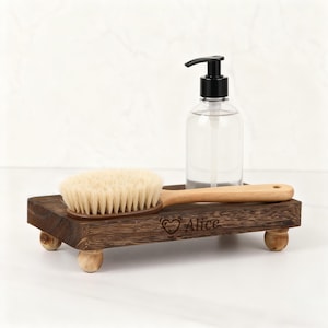 May include: A wooden tray with a natural bristle brush and a clear bottle with a black pump. The tray has a dark brown finish, rounded feet, and the name "Alice" engraved on it.