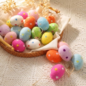 May include: A wicker basket filled with colourful, speckled Easter eggs. The eggs are various colours, including pink, blue, yellow, orange, and green, with white polka dots. Some eggs have twine attached.