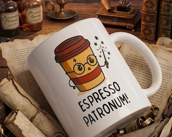 May include: A white ceramic mug featuring a cartoon coffee cup character with round glasses, a lightning bolt scar, and a wand. The text "ESPRESSO PATRONUM!" is printed in black below the character. The mug has a handle and a smooth finish.
