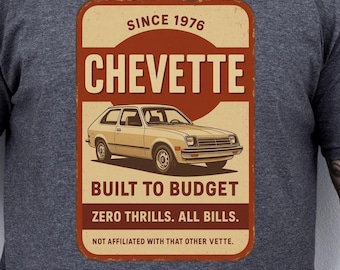 Może przedstawiać: Szara koszulka z grafiką w stylu retro. Grafika to prostokątny wzór z ilustracją beżowego samochodu oraz tekstem "CHEVETTE" i "BUILT TO BUDGET". Dodatkowy tekst to "SINCE 1976" i "ZERO THRILLS. ALL BILLS."
