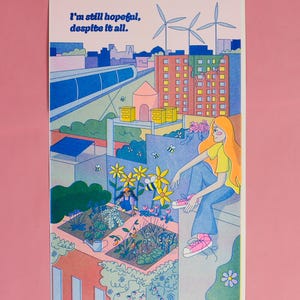 May include: Illustration of a rooftop garden scene with a person sitting and looking at the garden. The image includes the text "I'm still hopeful, despite it all." The scene features buildings, wind turbines, and bees.