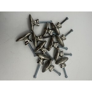 May include: A collection of ten silver-toned metal cabinet knobs, each featuring a smooth, rounded top and a cylindrical base. Every knob is attached to a long, threaded metal screw, providing a functional hardware component for furniture.