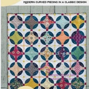May include: Indigo quilt pattern featuring a modern curved piecing design with a classic curves ruler. The quilt is made with a variety of colourful fabrics in shades of blue, green, yellow, pink, and red.
