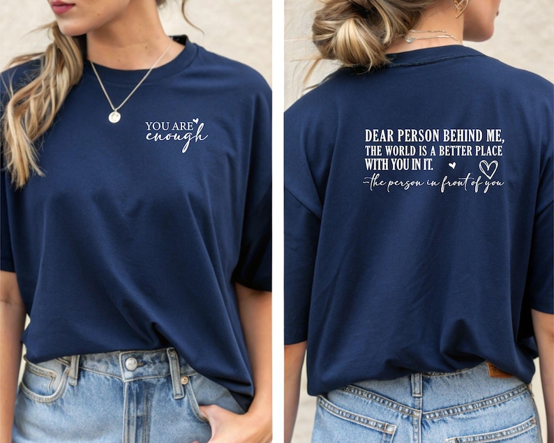 May include: Navy blue t-shirt with the text "YOU ARE enough" on the front. The back of the shirt features the message "DEAR PERSON BEHIND ME, THE WORLD IS A BETTER PLACE WITH YOU IN IT. -the person in front of you."