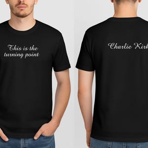 May include: Black crew neck t-shirt with the text "This is the turning point" on the front and "Charlie Kirk" on the back in white script. The shirt is a basic tee.