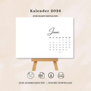 Könnte beinhalten: Ein weißer Kalender für 2026, präsentiert auf einer kleinen Holzstaffelei. Der Kalender zeigt den Monat Januar in minimalistischem Design. Der Text oben lautet "Kalender 2026" und "ZUM SELBST GESTALTEN". Unten steht "ZUM AUSDRUCKEN PDF | SOFORT DOWNLOAD".