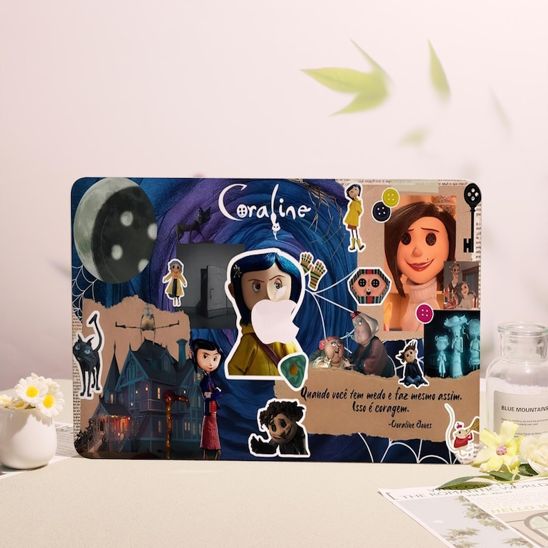 May include: A rectangular Coraline-themed laptop skin featuring various character stickers and the film's title. The design includes a moon, a house, and a quote in Portuguese. The background is a mix of blue, purple, and brown.