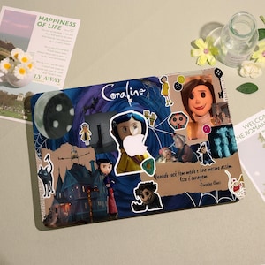 May include: A laptop case featuring a collage of images and text from the movie "Coraline." The design includes illustrations of characters, a moon, and the film's title. The case is decorated with stickers and a quote.