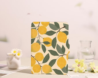 May include: A rectangular, cream-colored case featuring a pattern of yellow lemons and green leaves on branches. The design is repeated across the surface. The case is set against a neutral background with decorative elements.