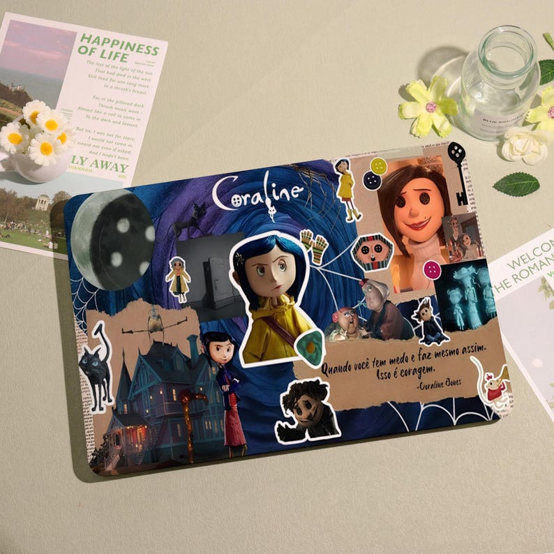 May include: A decorative laptop skin featuring imagery from the movie "Coraline." The design includes character stickers, a moon, and the film's title. The quote "Quando voc&ecirc; tem medo e faz mesmo assim. Isso &eacute; coragem." is also visible.