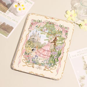 May include: A tablet case with a romantic illustration of a woman in a pink dress in a garden with a castle. The case has a floral border and a light beige background. The design evokes a fairytale theme.