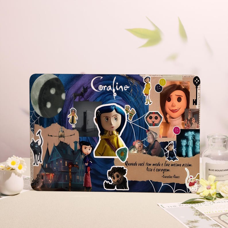 May include: A decorative collage featuring imagery from the movie "Coraline." The design includes illustrations of characters, a crescent moon, and the film's title. The color palette includes blues, purples, and browns.