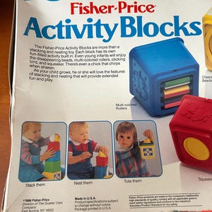 May include: A Fisher-Price Activity Blocks box, featuring the product name in blue. The box shows images of children playing with the blocks. Text describes the toy's features, including stacking and nesting capabilities.