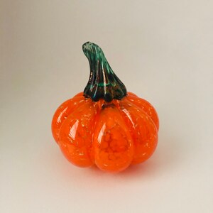Handblown orange glass pumpkin with a green stem
