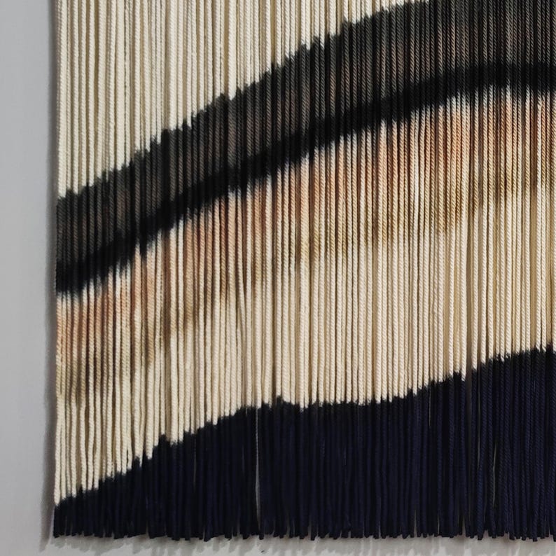 Peut inclure: Une tapisserie murale en fil avec un motif g&eacute;om&eacute;trique de rayures noires, blanches et brunes. Le fil est tiss&eacute; de mani&egrave;re &agrave; cr&eacute;er un effet textur&eacute; et tridimensionnel.