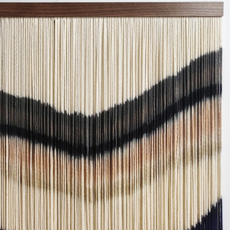 Peut inclure: Une tapisserie murale en fil tiss&eacute; dans des tons de blanc, beige, noir et marron. Le fil est dispos&eacute; en forme de chevron, cr&eacute;ant un motif g&eacute;om&eacute;trique.