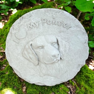May include: A round, light gray stone garden stepping stone with the words "My Pointer" and a heart carved into the surface. The stone features a detailed relief of a dog's head.
