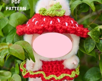 May include: A plush doll wearing a red and white strawberry outfit, with a green crocheted stem. The text "MONSTER DOLL STRAWBERRY OUTFIT" is at the top, with "PDF PATTERN" and "DIGITAL DOWNLOAD" on the sides.