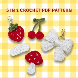 May include: A collection of handmade crochet items, including a red strawberry keychain, a pair of red cherry charms, a white bow keychain, a white cloud, and a red mushroom. The text "5 IN 1 CROCHET PDF PATTERN" is at the top.