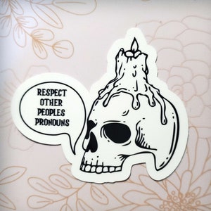 May include: Black and white sticker of a skull with a candle on top. The skull is wearing a speech bubble that says "Respect Other Peoples Pronouns".