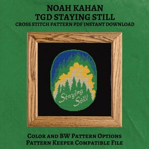 May include: A cross-stitch pattern featuring a landscape design with the text "Staying Still." The design includes green, yellow, and blue elements, framed in a wooden border. The text "NOAH KAHAN TGD STAYING STILL" is at the top.