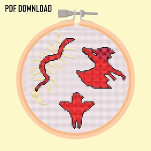 May include: A cross-stitch embroidery hoop with a white background and three red designs: a bird, a snake, and a dragon. The snake is curled up and the dragon is flying. The bird is standing on the ground.