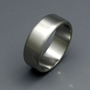 May include: A silver wedding band with a smooth, rounded surface.