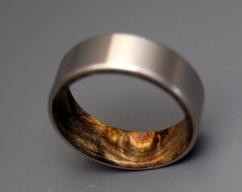 May include: A silver ring with a wooden inlay. The wood has a dark brown and light brown swirl pattern.
