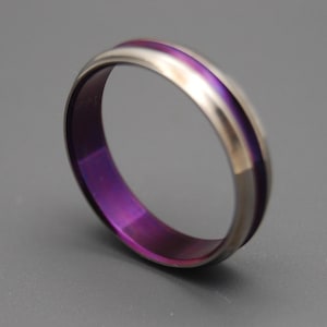 May include: A purple and silver titanium wedding band with a polished finish.