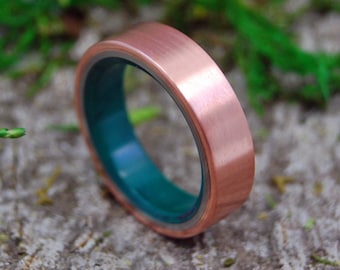 May include: A copper ring with a brushed finish and a teal green inlay.