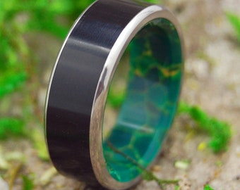 May include: A black and green ring with a silver band. The ring is made of wood and resin.